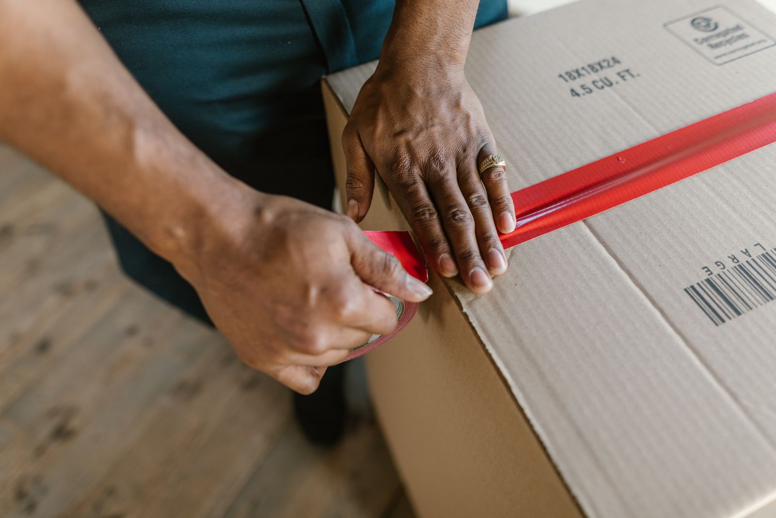 Hands preparing a cardboard box, representing the item details used for an estimate.