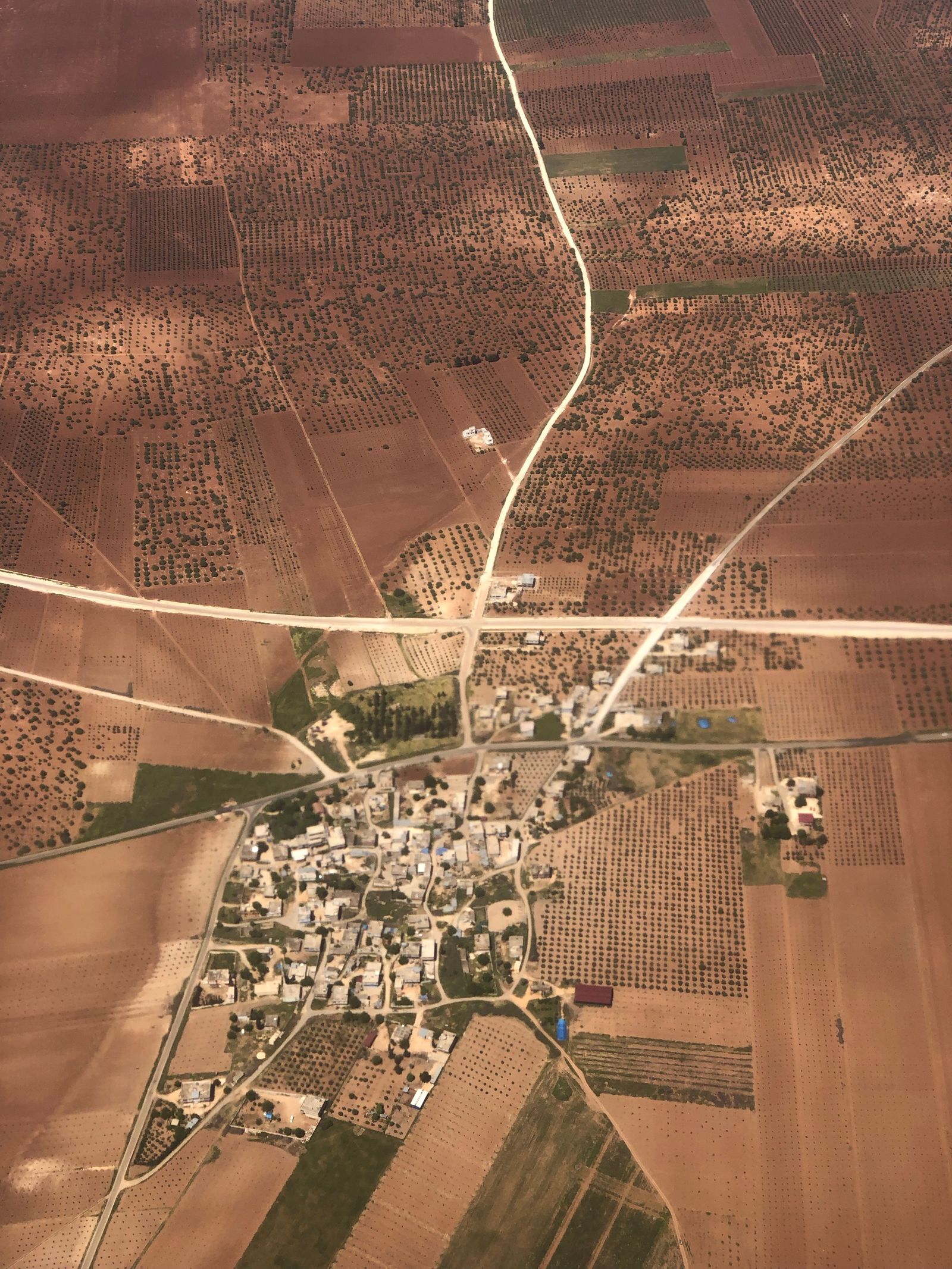 A small town surrounded by farmland and roads, representing rural access and distance.